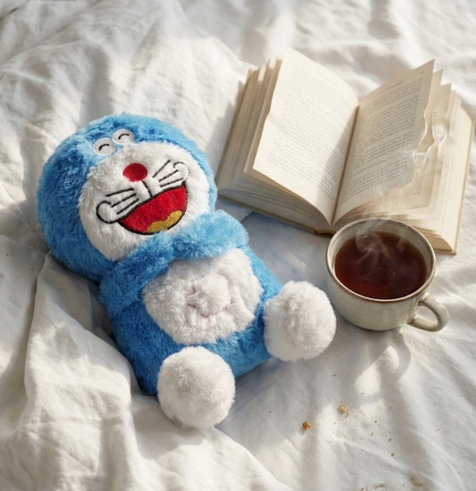 Breathing Doraemon next to a cup of tea and an open book on a white surface