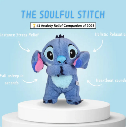 Blue plush toy with heart-shaped belly on a white pedestal against a light blue background, labeled 'The Soulful Stitch'