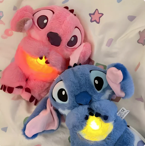 Two plush toys, one pink and one blue, with glowing yellow hearts on a patterned background.
