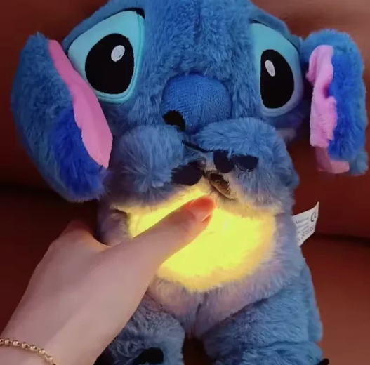 Blue plush toy with glowing yellow heart being held by a hand against a brown background